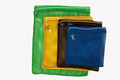 Four mesh bags of golf balls in different colors on a white background