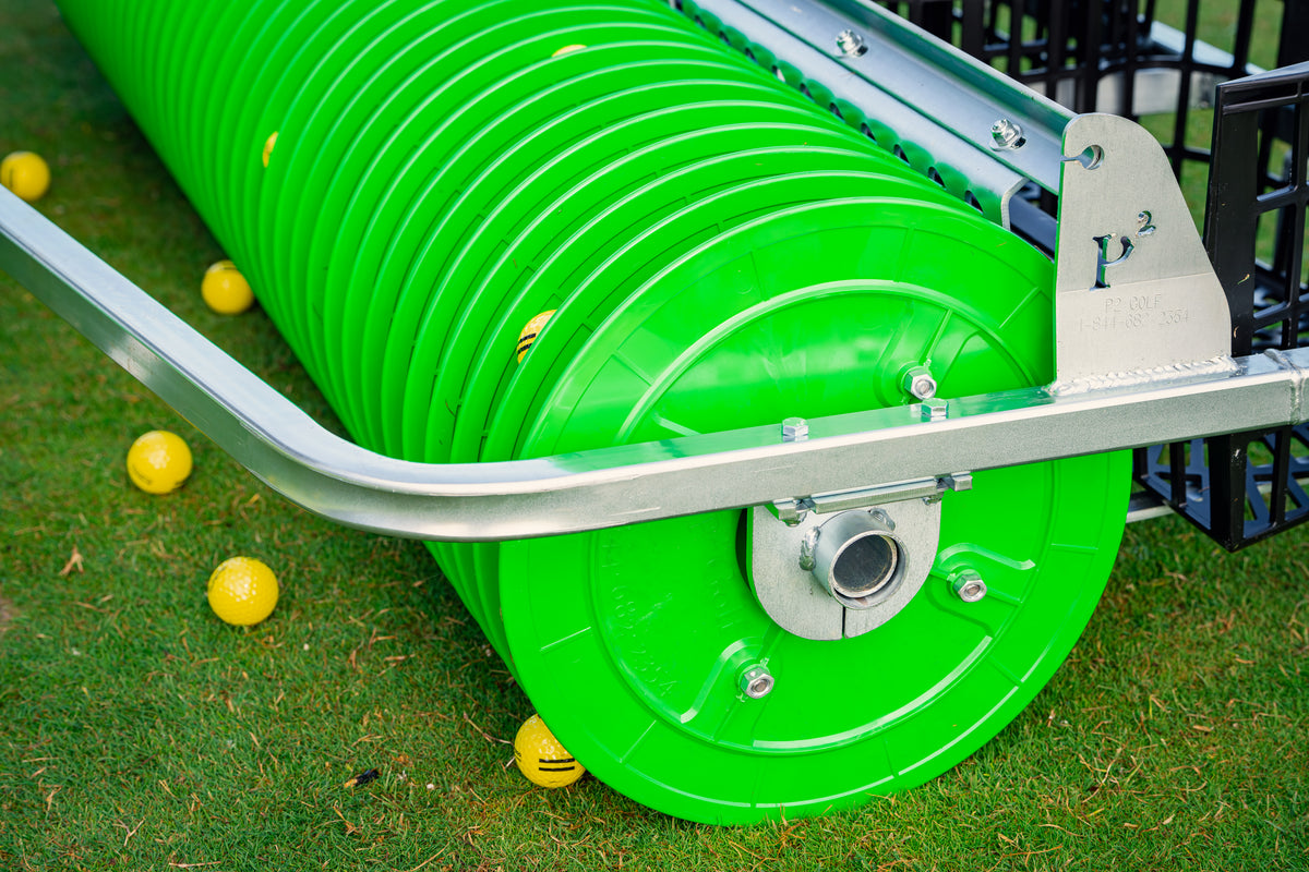 Green plastic picker disc set on grass, surrounded by yellow balls